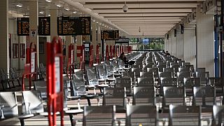 A person sits on a seat in an otherwise empty bus station in Huddersfield, northern England