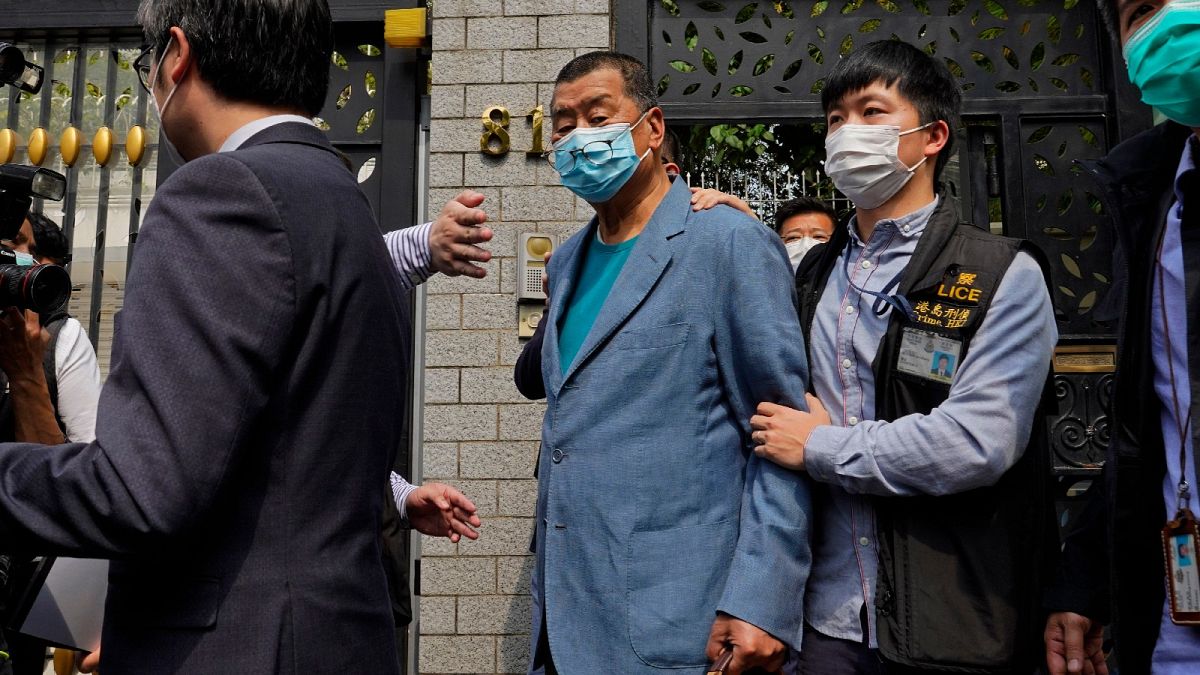 Hong Kong media tycoon Jimmy Lai, center, who founded local newspaper Apple Daily, is arrested by police officers at his home in Hong Kong, Saturday, April 18, 2020