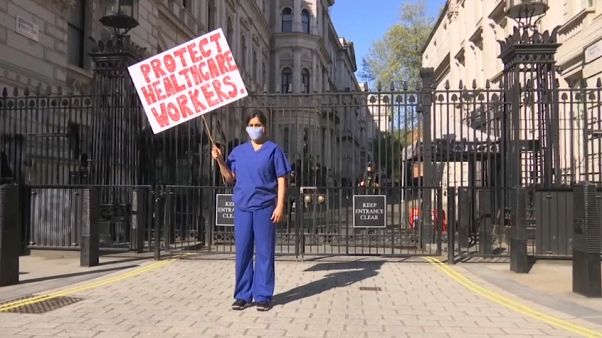 Eine Ärztin protestiert vor dem Amtssitz des Premierministers in London. Eine Ärztin protestiert vor dem Amtssitz des Premierministers in London.
