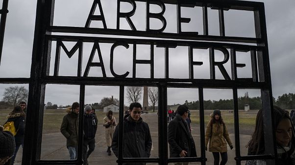 Visitors walk past the gate of the former Sachsenhausen concentration camp Visitors walk past the gate of the former Sachsenhausen concentration camp