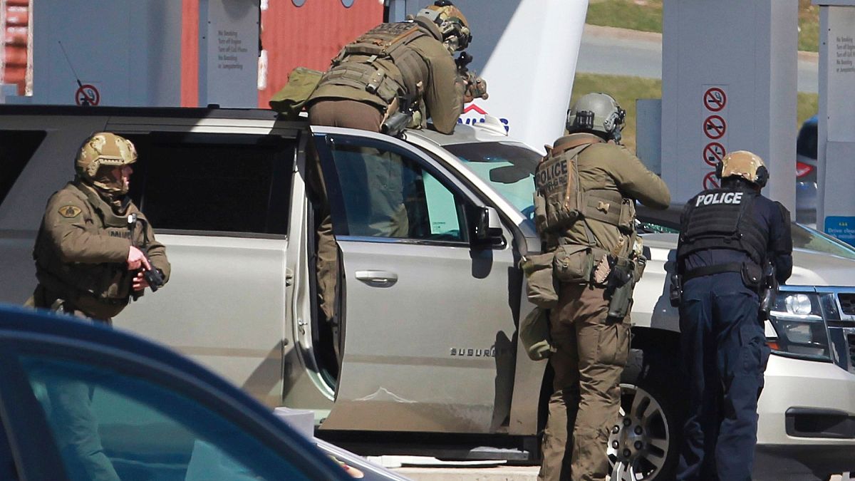 Royal Canadian Mounted Police officers surround a suspect at a gas station in Enfield, Nova Scotia, April 19, 2020