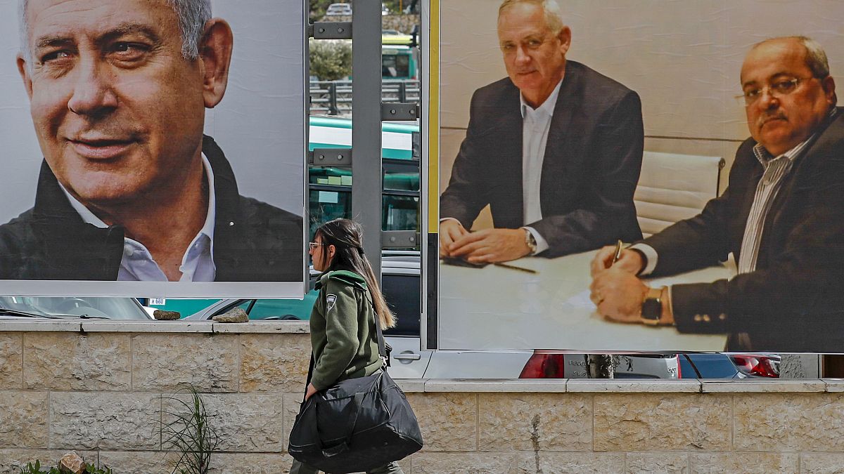 Israelische Soldatin vor Wahlplakaten mit Ministerpräsident Netanjahu und Oppositionsführer Gantz