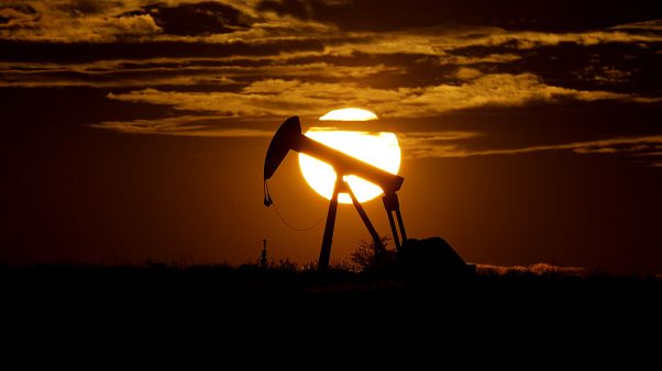 In this Wednesday, April 8, 2020, file photo, the sun sets behind an idle pump jack near Karnes City, Texas. 