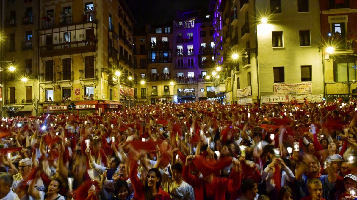 Los juerguistas sostienen velas y pañuelos rojos cantando ''Pobre de Mi'' para cerrar San Fermín 2019 el 15 de julio en Pamplona.