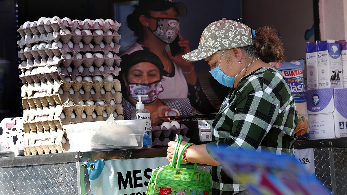 Una mujer compra en un mercado mexicano
