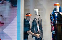 A fashion shop employee wearing a face mask adjusts a mannequin in Moscow, Russia, Tuesday, April 14