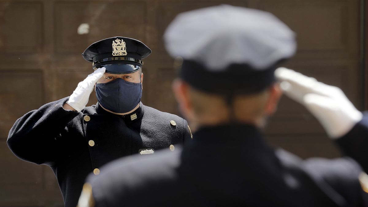 عنصران من حرس الشرف في شرطة نيويورك يؤديان التحية خلال تأبين قائد في الشرطة توفي بعد إصابته بكورونا  