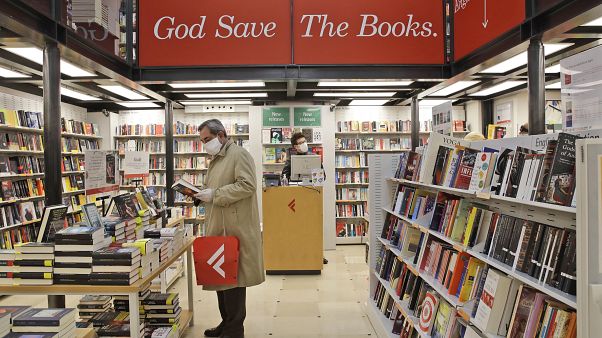 Un hombre ojea un volumen en una librería de Roma Un hombre ojea un volumen en una librería de Roma