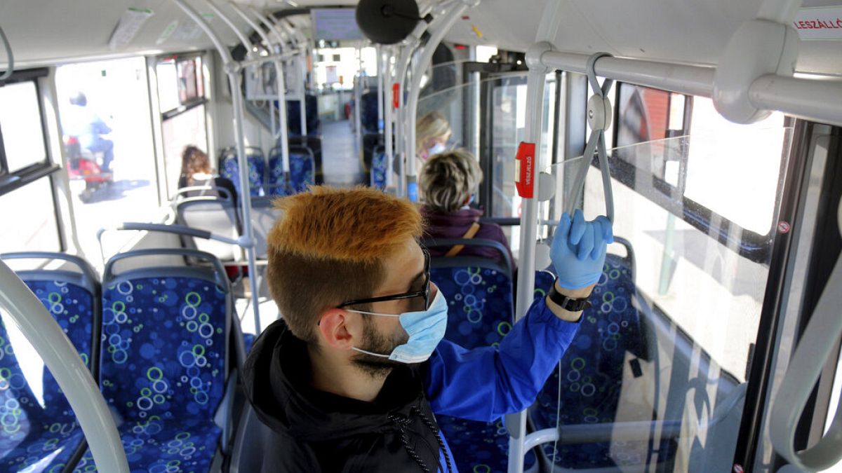 A man uses facial mask and gloves while riding on a public bus as a preventive measure against the coronavirus in Miskolc, Hungary, April 23, 2020
