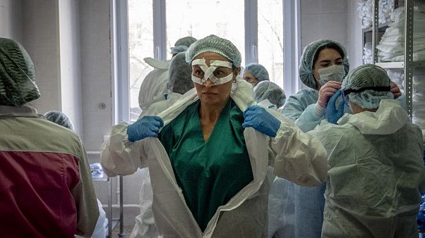 Los trabajadores médicos se preparan para un turno de tratamiento de pacientes con coronavirus en el hospital clínico Spasokukotsky en Moscú el 22 de abril de 2020. 