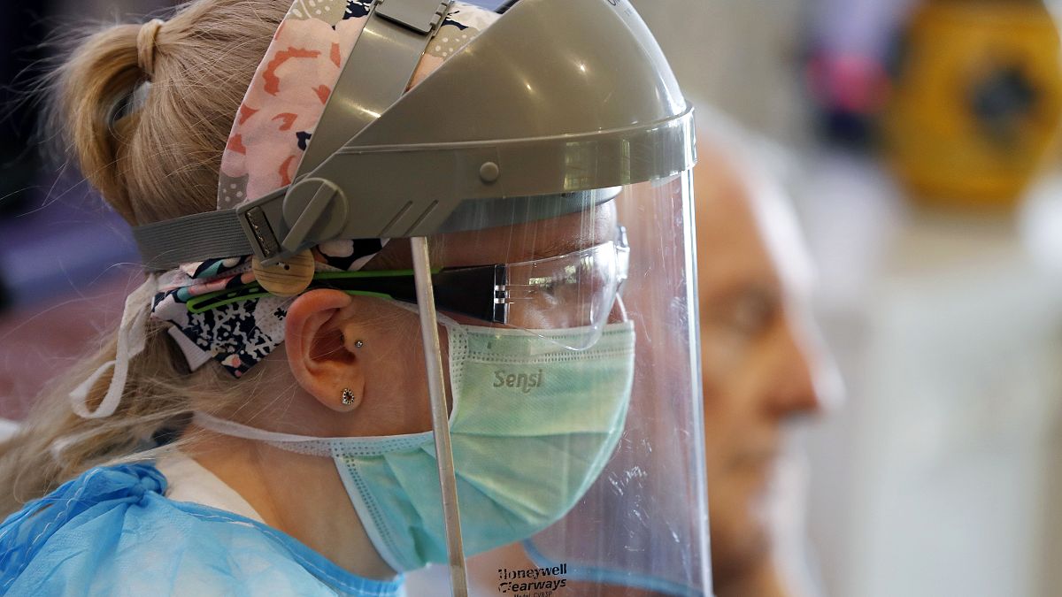 A nurse wears protective gear at Wren Hall nursing home in the central England village of Selston. 
