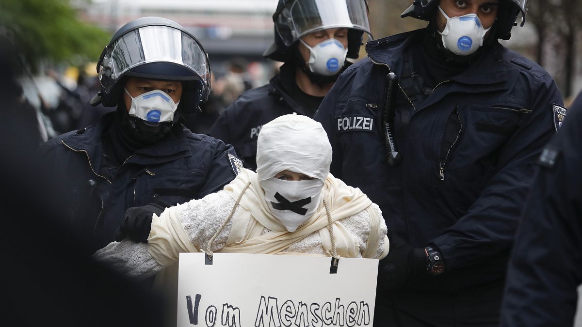 Police officers detain a person during an illegal demonstration against restrictions and measures to prevent the spread of COVID-19 in Berlin, Germany, on April 25.