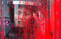 A police officer stands behind her riot shield covered in red paint during an International Women's Day march in Mexico City's main square, Sunday, March 8, 2020.