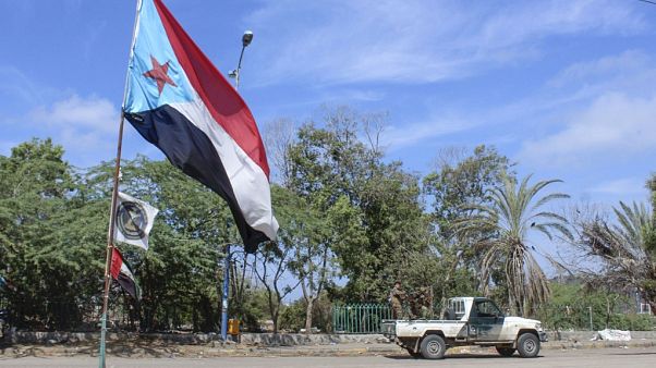 Fighters with Yemen's Southern Transitional Council (STC) drive a vehicle past a separatist flag Fighters with Yemen's Southern Transitional Council (STC) drive a vehicle past a separatist flag