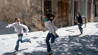 طفلان يركضان في شوارع برشلونة أمس الأحد بعدما سمحت السلطات للأطفال بالخروج لمدة زمنية محددة