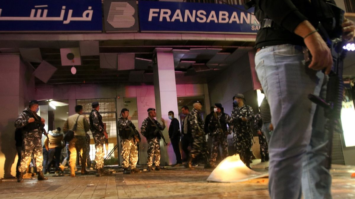 Lübnan'ın güneyindeki Sidon şehrinde güvenlik güçleri patlayıcı atılan bir bankanın girişinde incelemelerde bulunuyor
