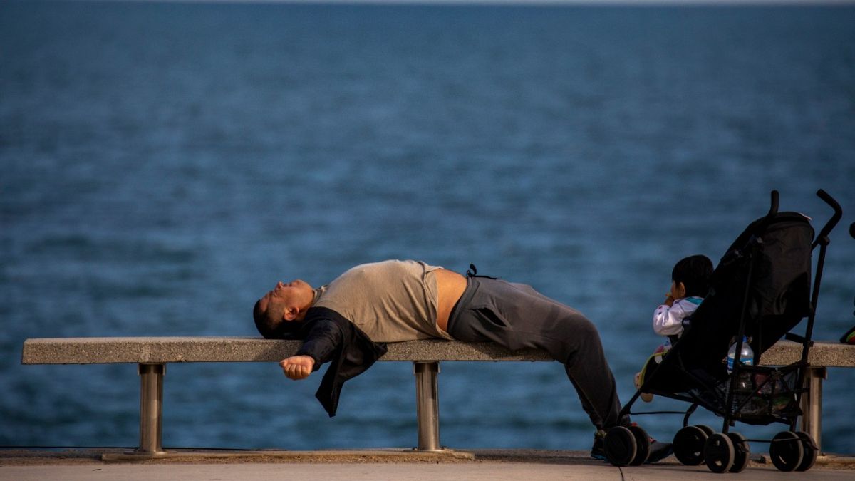 رجل مستلق على شاطئ في مدينة برشلونة الإسبانية - 2020/04/26