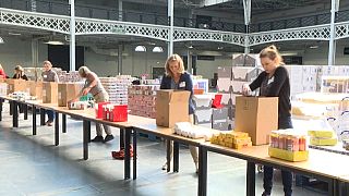 Volunteers putting food into boxes at London Olympia