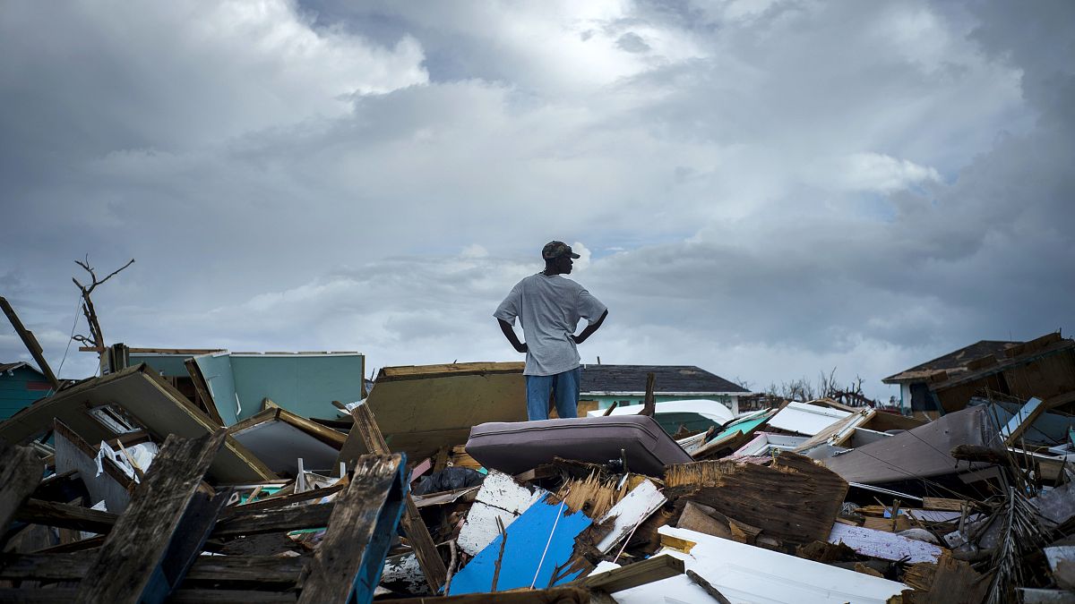 Un hombre está de pie sobre los escombros de su casa en el barrio haitiano, tras el paso del huracán Dorian en Abaco, Bahamas, el lunes 16 de septiembre de 2019. 