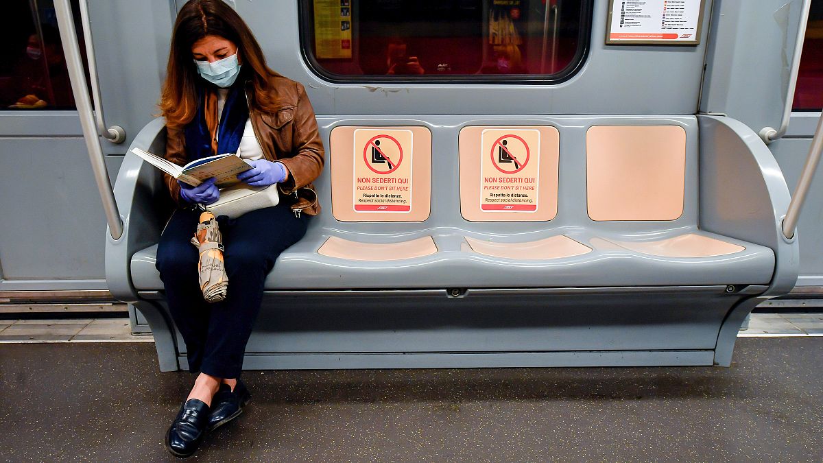 The signs reading ‘Please do not sit here, respect social distancing’ are visible on the seats in a metro train in Milan, Italy.