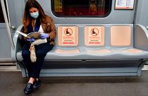The signs reading ‘Please do not sit here, respect social distancing’ are visible on the seats in a metro train in Milan, Italy.