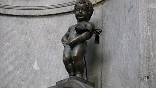 شاهد: إلتزاماً بالقيود الصحية.. تمثال "الصبي المتبول" وسط بروكسل يضع كمامة