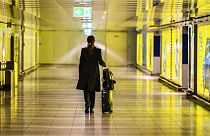 Eine Reisende schiebt ihren Koffer durch einen leeren Gang am Frankfurter Flughafen, 12. März 2020.