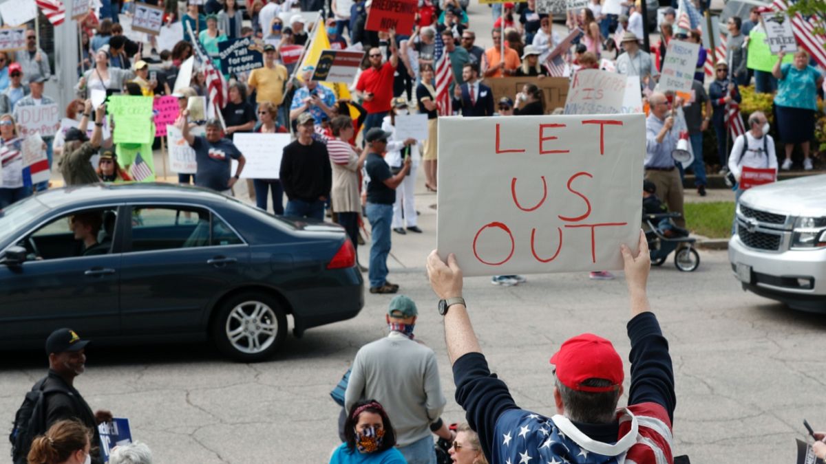 ABD'nin Kuzey Carolina eyaletinde bir gösterici koronavirüs tedbirlerini elindeki "Bizi dışarı bırakın" pankartıyla protesto ediyor