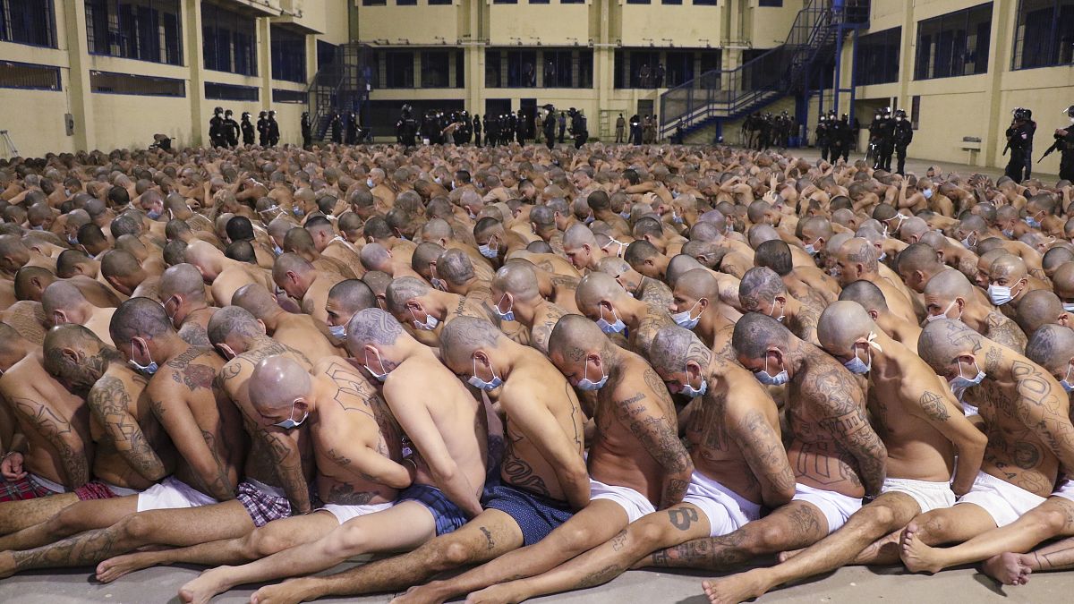 Los reclusos alineados durante una operación de seguridad bajo la vigilancia de la policía en la prisión de Izalco en San Salvador, El Salvador, el sábado 25 de abril de 2020.