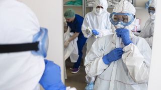 Medical workers put on protective gear in order to assist coronavirus patients at the intensive care unit of Vinogradov City Clinical Hospital in Moscow, Russia. 