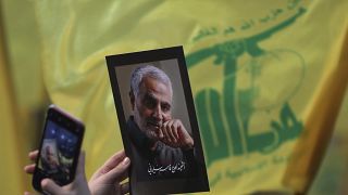 أحد مؤيدي حزب الله رافعاً صورة لقائد الحرس الثوري الإيراني السابق قاسم سليماني