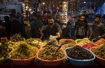 A Palestinian vendor wears a face mask as a protection against the spread of the coronavirus as he sells pickles in the Zawiya market during a Ramadan day in Gaza City