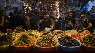A Palestinian vendor wears a face mask as a protection against the spread of the coronavirus as he sells pickles in the Zawiya market during a Ramadan day in Gaza City