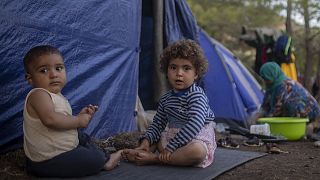 Syrians children play outside a makeshift tent near the refugee and migrant camp at the Greek island of Samos