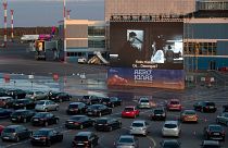 People sit in their cars watching a movie at a new drive-in cinema at the airport in Vilnius, Lithuania on April 29, 2020.