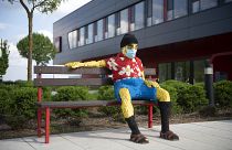 Padon ülő figura maszkban a nyíregyházi Lego-gyár előtt