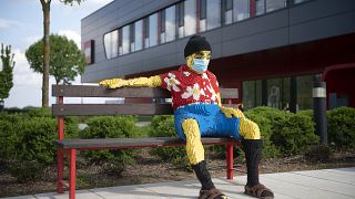 Padon ülő figura maszkban a nyíregyházi Lego-gyár előtt