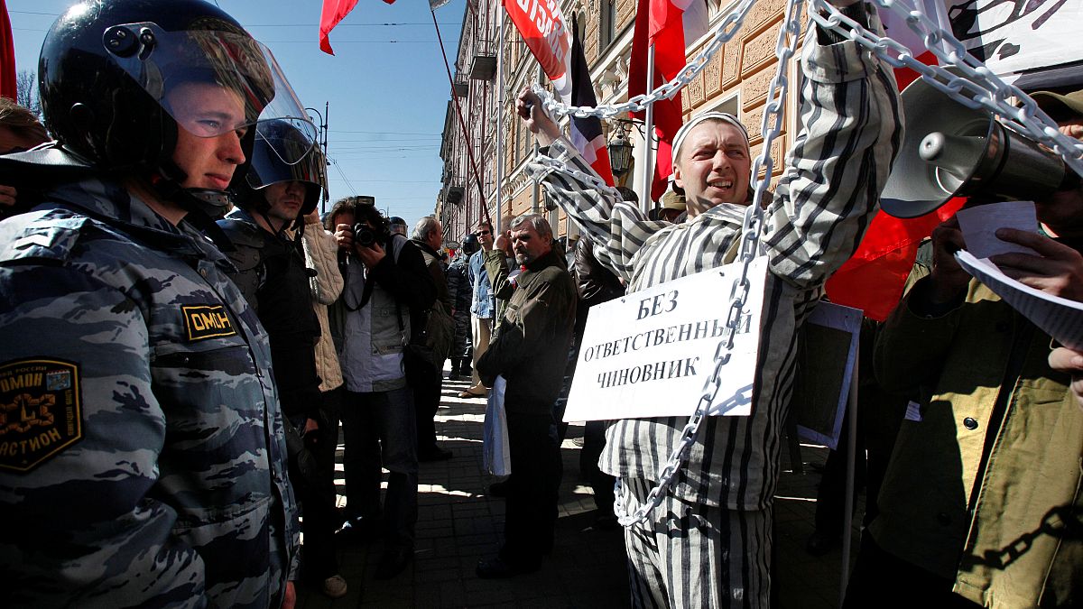 Officers cordon off an area near a performer staging a street protest during a Russian Communist Party march marking May Day in downtown St. Petersburg May 1, 2009. 