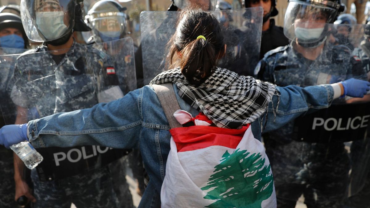 A protester confronts police during a demonstration against the deepening financial crisis, in Beirut, Lebanon, Tuesday, April 28, 2020