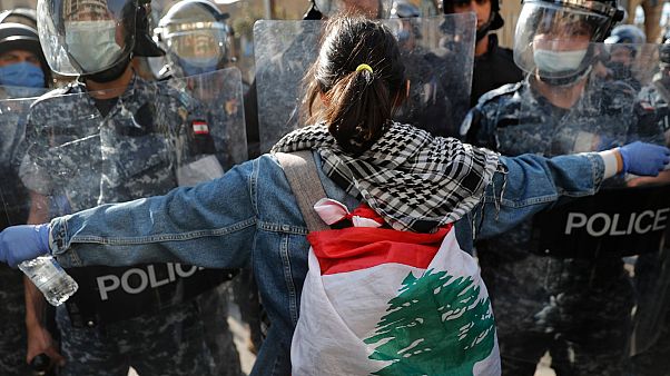 A protester confronts police during a demonstration against the deepening financial crisis, in Beirut, Lebanon, Tuesday, April 28, 2020 A protester confronts police during a demonstration against the deepening financial crisis, in Beirut, Lebanon, Tuesday, April 28, 2020