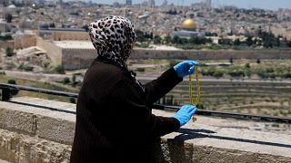 سيدة فلسطينية ترنو بنظراتها للمسجد الأقصى في القدس بعد إغلاقه بسبب وباء كورونا 01-05-2020