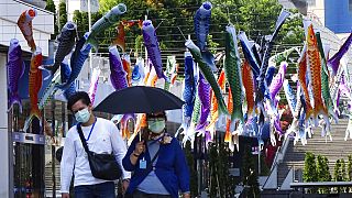 Maszkot viselő járókelők Japánban, 2020. május 2.