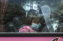 A child migrant looks from a bus window outside Moria camp on her way to the port of Mytilene, on the northeastern Aegean island of Lesbos, Greece, on May 3, 2020