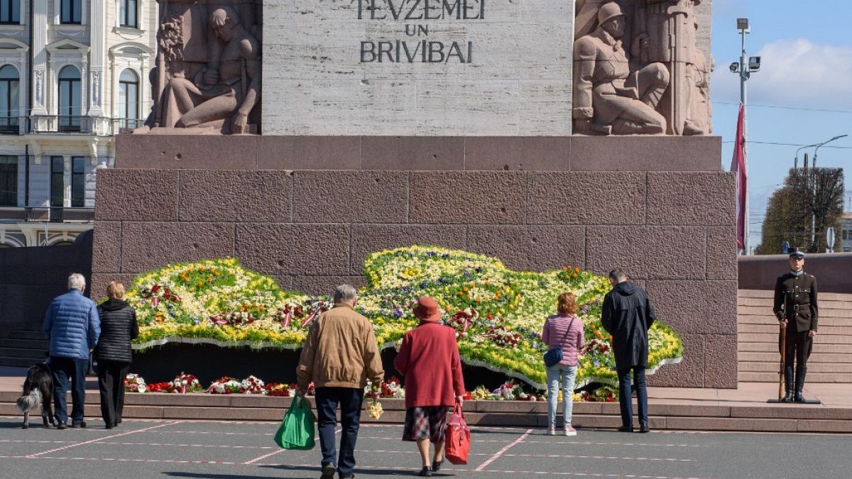 People arrive to lay a wreath in front of the Monument of Freedom to mark the 30th anniversary of the restoration of independence of the Republic of Latvia on May 4, 2020