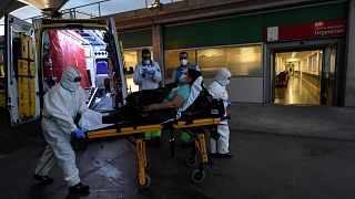 وحدة خدمات الطوارئ الطبية في مدريد ينقلون مريضة مشتبه بإصابتها بالفيروس إلى المستشفى- 19 أبريل 2020