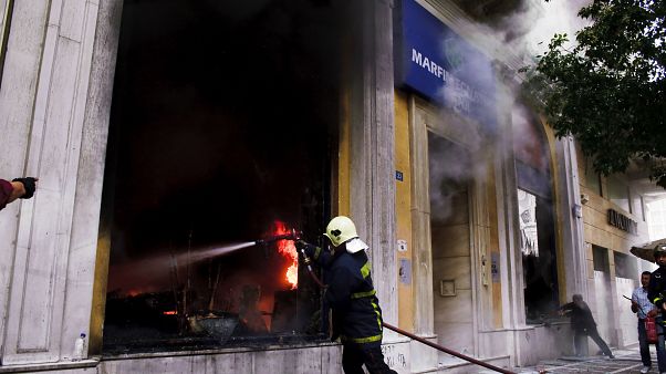 A firefighter tries to extinguish a fire at the branch of Marfin Egnatia Bank, where three people died, in central Athens, Wednesday, May 5, 2010 A firefighter tries to extinguish a fire at the branch of Marfin Egnatia Bank, where three people died, in central Athens, Wednesday, May 5, 2010