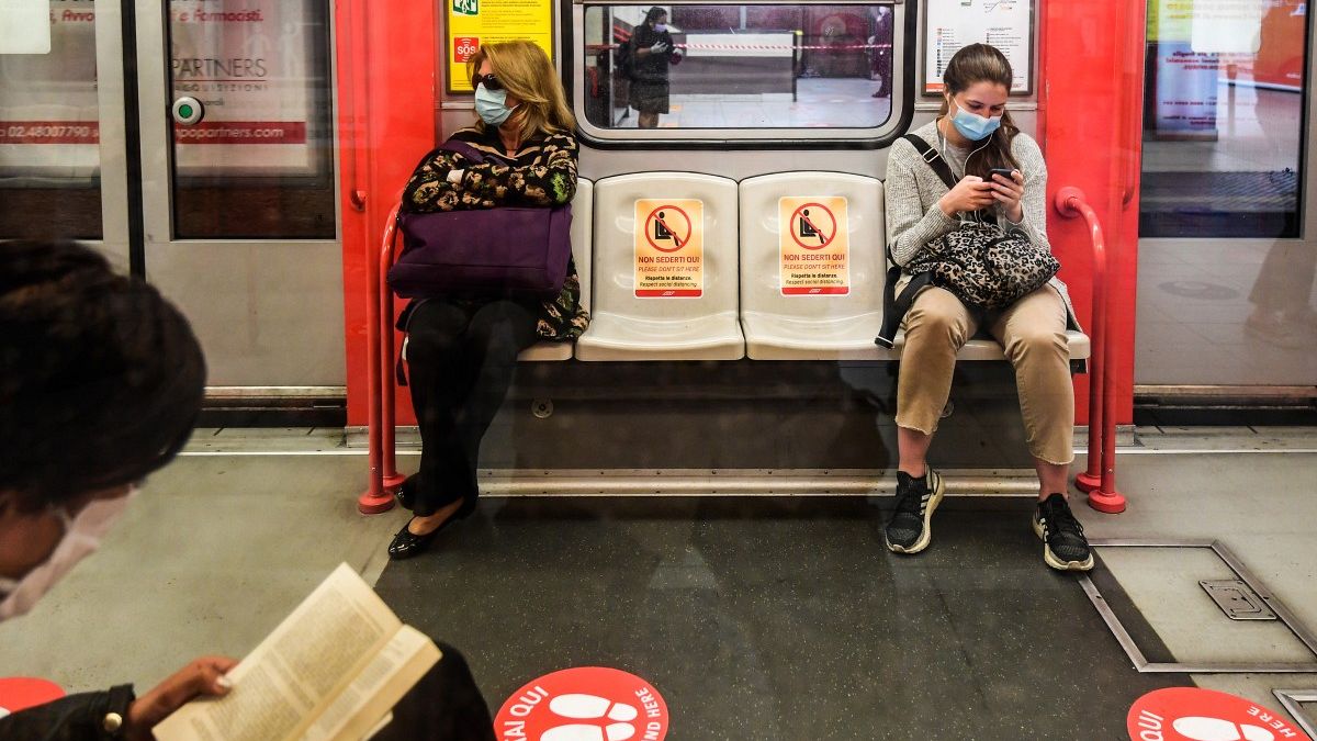 Des passagers dans le métro de Milan respectent la distanciation physique laissée par deux fauteuils vides