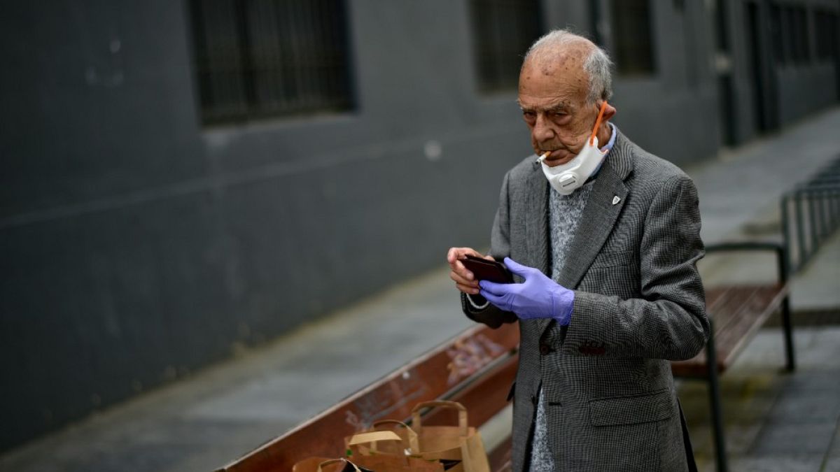 Un uomo con il viso parzialmente coperto da una mascherina, fuma una sigaretta a Pamplona (Spagna). 02/05/20