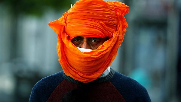 A man wears a makeshift face mask during the coronavirus lockdown in London, Tuesday, May 5, 2020. 