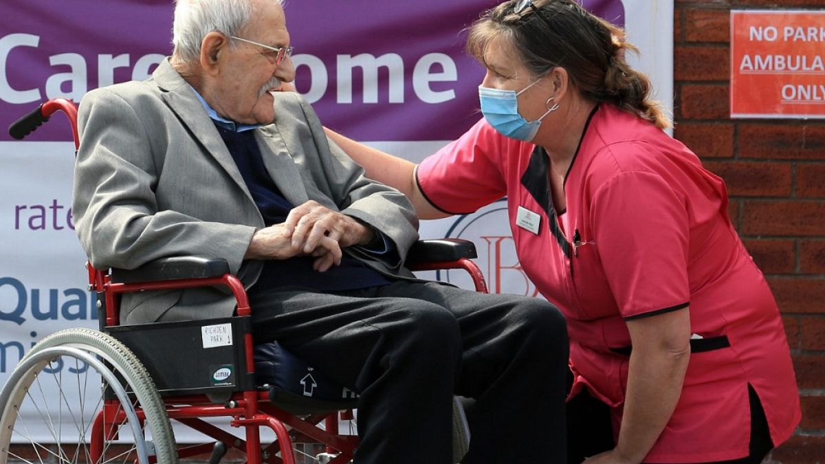 98-year-old care home resident Albert Rose talking to carer Jeanette on his birthday in Scunthorpe, UK on May 4, 2020, (Photo by Lindsey Parnaby / AFP)